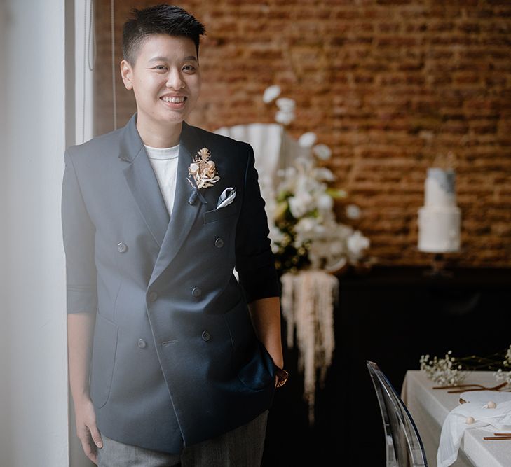 Asian Lesbian bride in a white t-shirt and navy double breasted suit jacket 