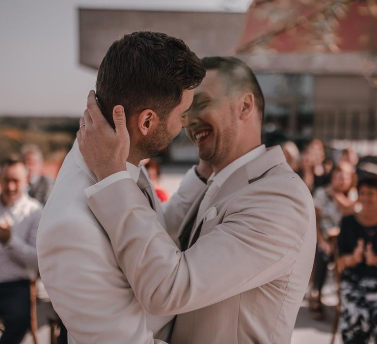 Grooms kiss during wedding ceremony