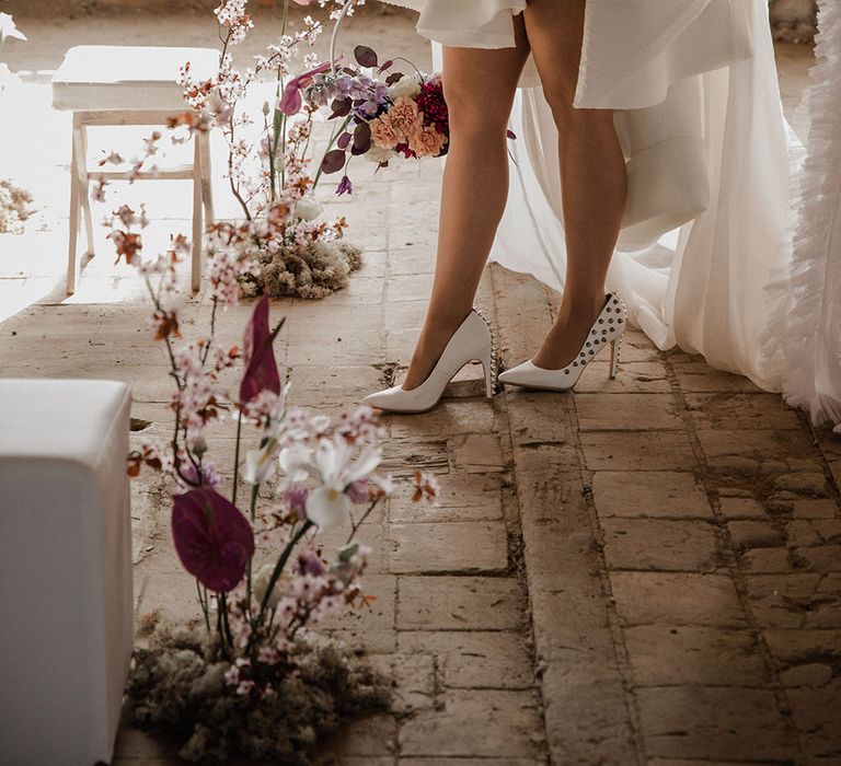 Bride in a mini wedding dress with white studded heels 