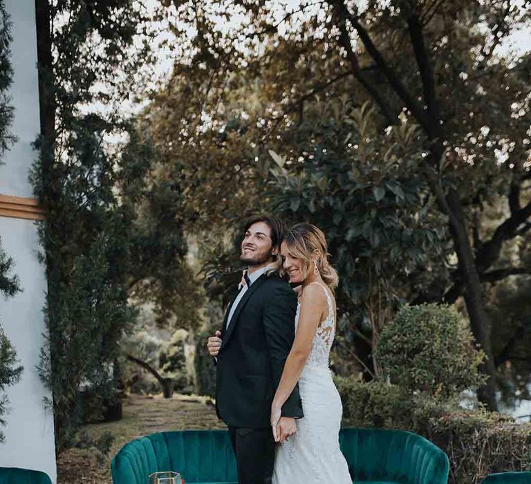 Bride and groom with green seating area at romantic elopement