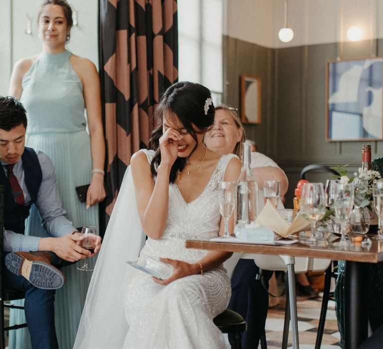 The bride smiling and hiding her face during the speeches