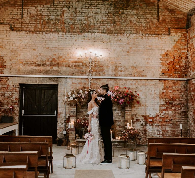 Botley Hill Barn wedding ceremony with pink and red floral arch and lanterns 