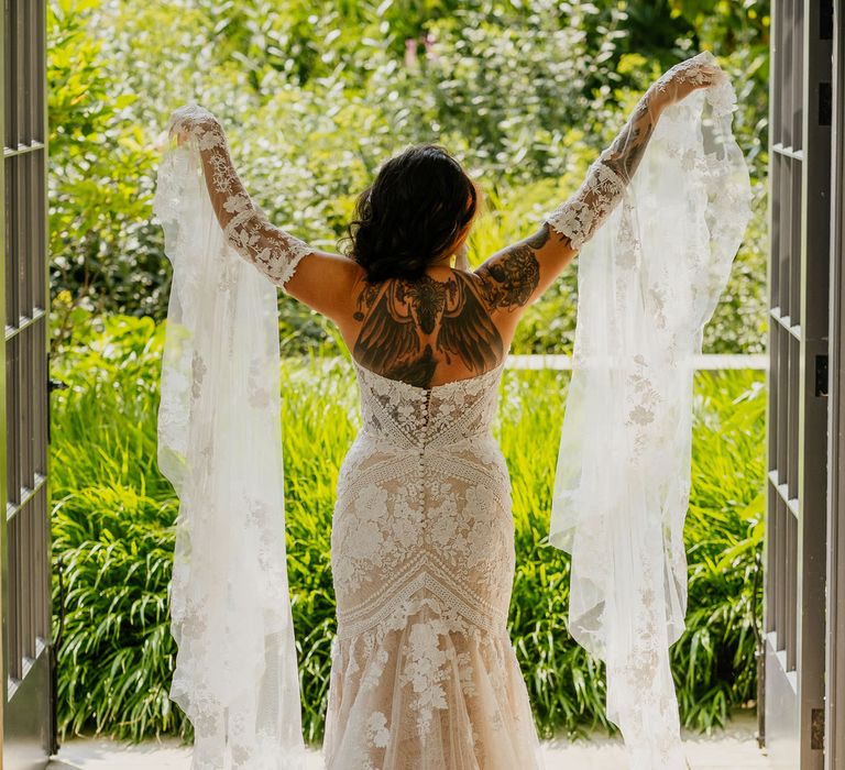 Bride in a lace wedding dress with mermaid tail and detachable bell sleeves for fiesta theme wedding 