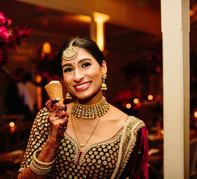 Bride smiles brightly at the camera as she holds ice cream on her wedding day