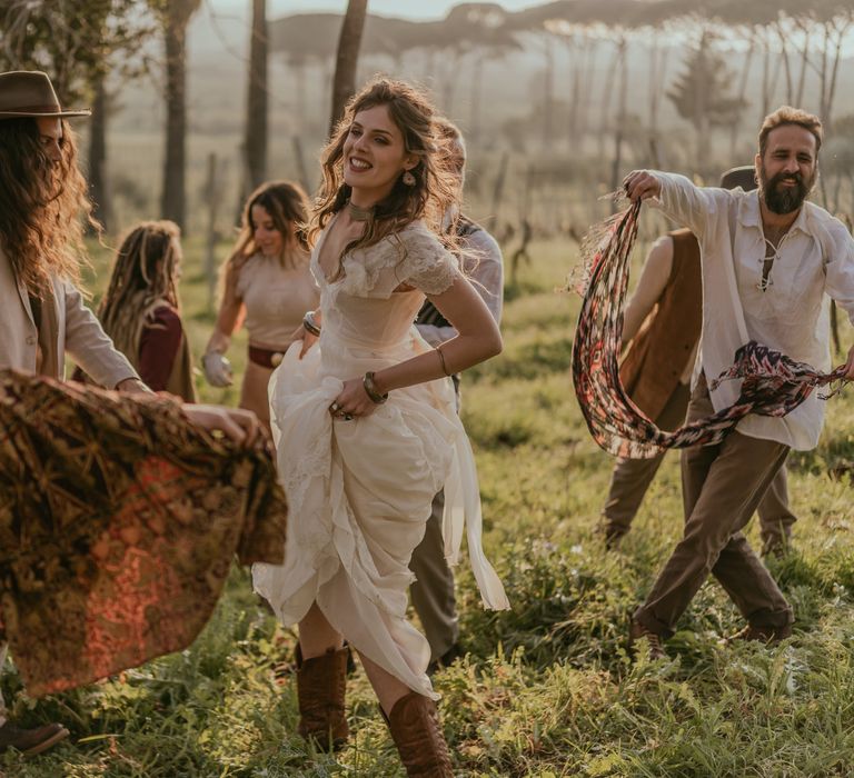 Bride & groom dance with wedding guests as they celebrate their marriage in the countryside of Sicily 