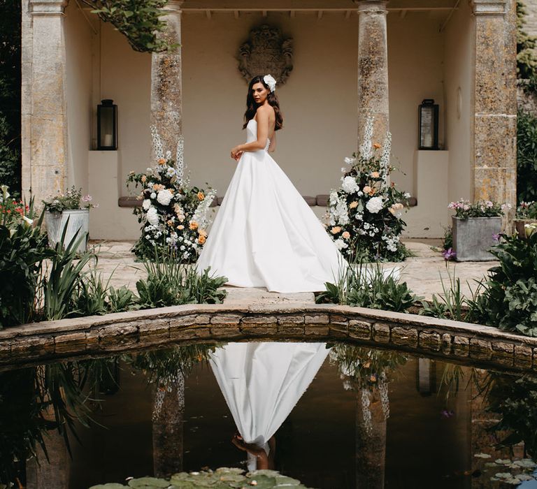 Bride in a strapless Suzanne Neville bridal gown with white and peach wedding flowers 