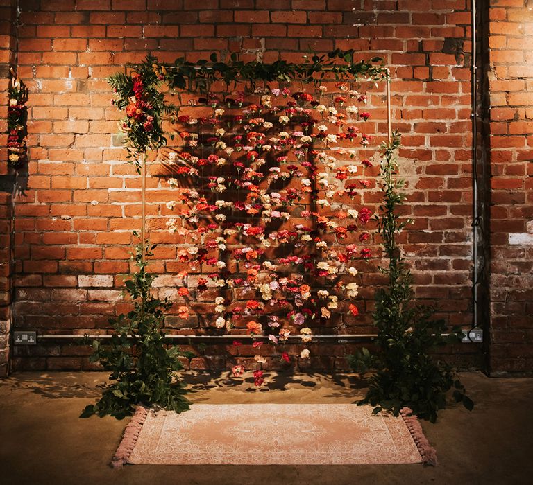 A floral installation makes the backdrop for a wedding ceremony.