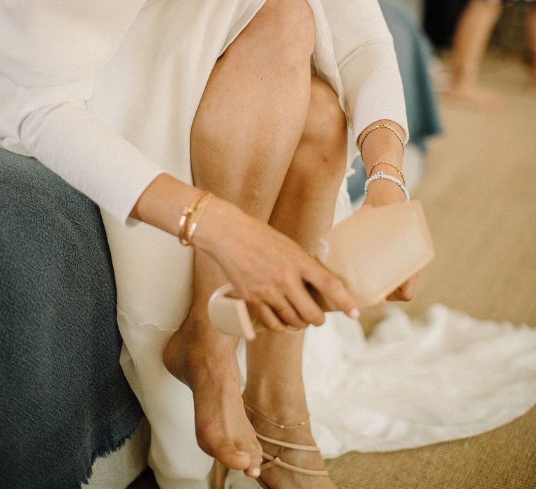 Bride wears nude coloured bridal shoes with thing straps on the day of her wedding day