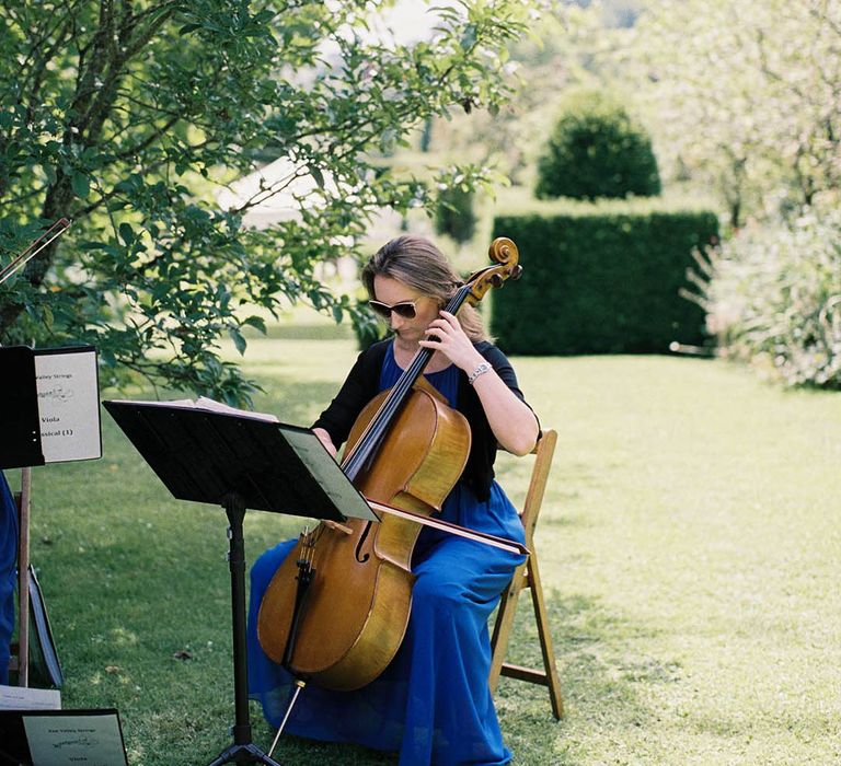 String quartet play during wedding ceremony outdoors on summers day