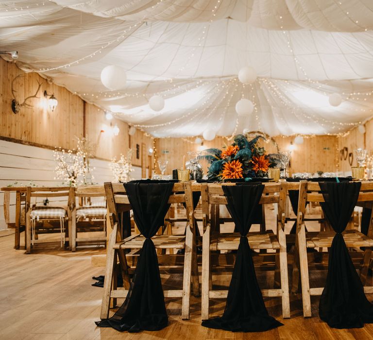 Rustic wedding reception with wooden chairs, tables and fairy lights for Wellbeing Farm wedding in Lancashire