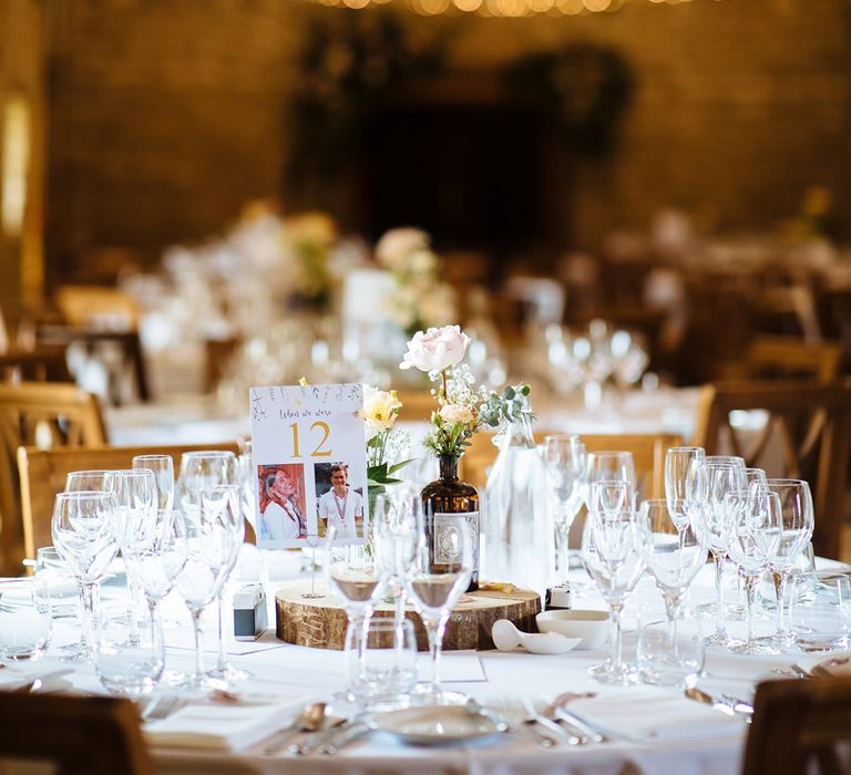 Rustic wedding venue wedding table centrepiece with wooden slice and picture table name signs 