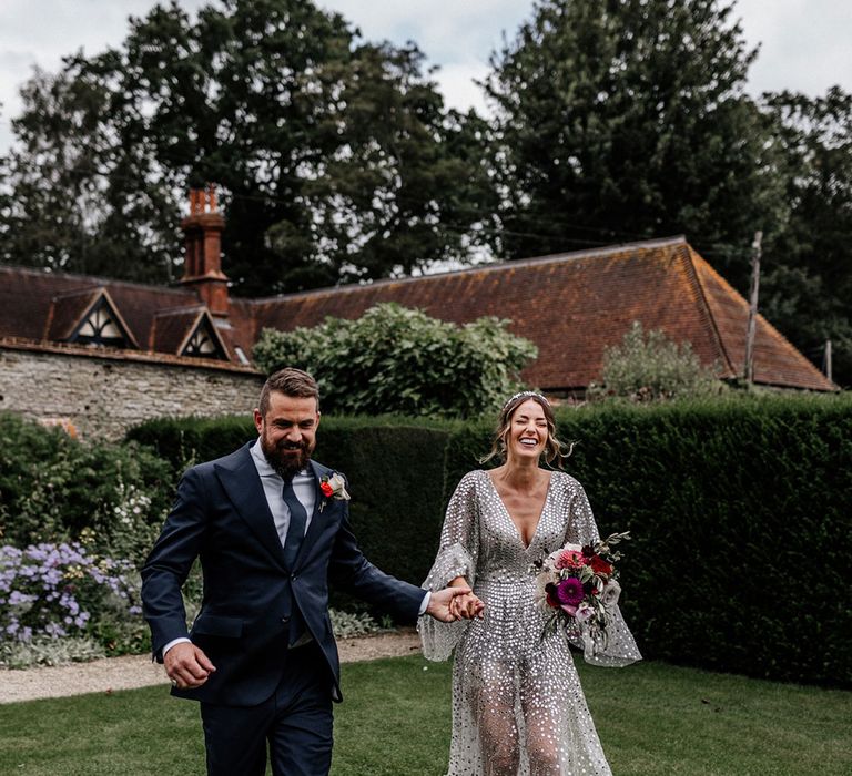 Groom in navy suit and bride silver sparkly wedding dress