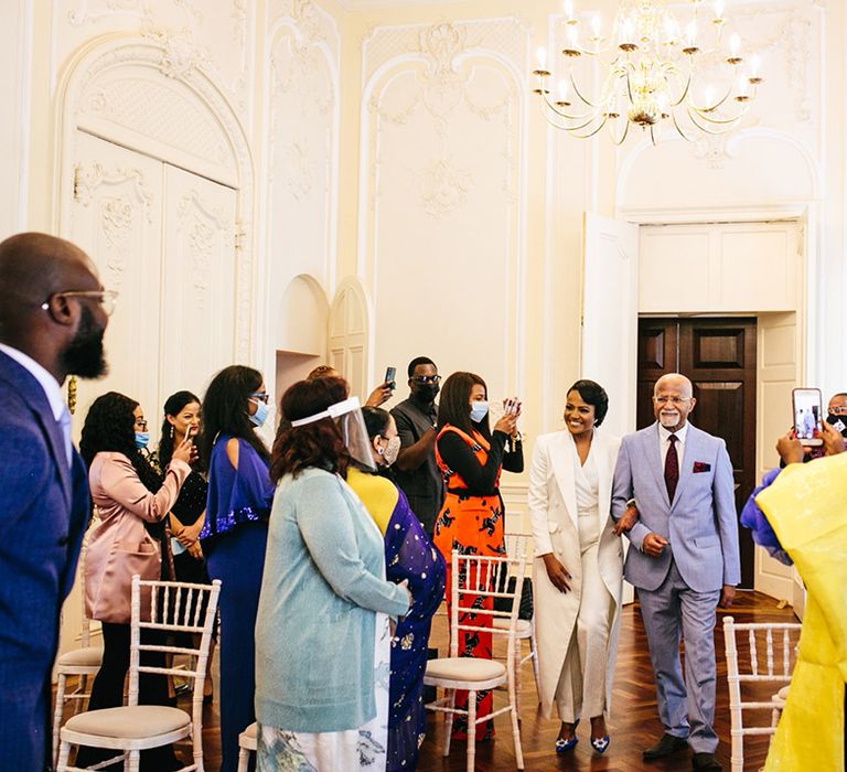 Bride walks down the aisle with father of the bride on her wedding day