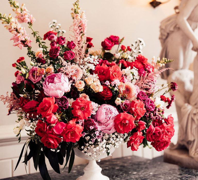 Large floral installation full of white, pink and red wedding flowers at Elmore Court in the Cotswolds