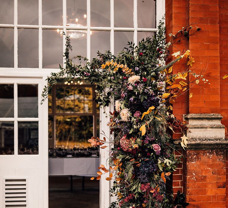 Flower arrangement full of autumn colours & a range of different flowers 