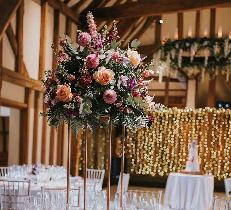 Muted pink tablescape with copper cutlery with tall flower centrepieces