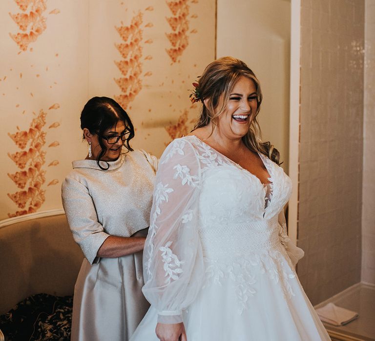 Curvy bride in a White Rose Bridal wedding dress with sheer embroidered sleeves on her wedding morning 