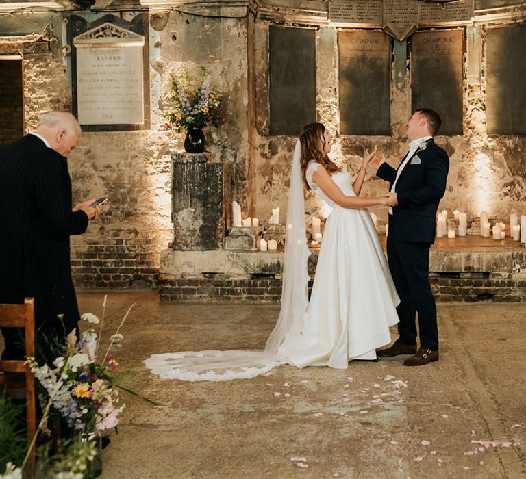 Bride in two-piece high low wedding skirt and cathdral length veil with lace detail at Asylum Chapel wedding venue