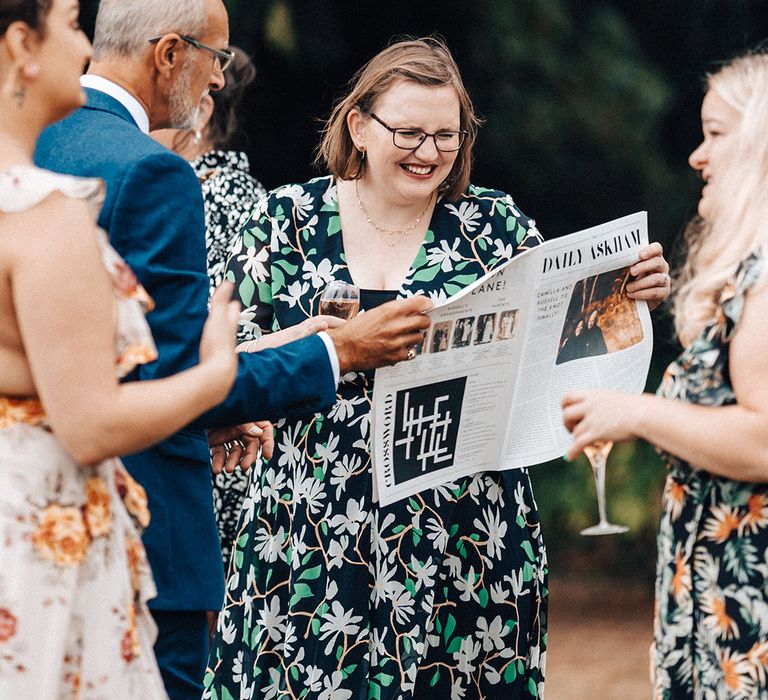 Wedding guests read personalised newpsaper from the wedding venue, Askham Hall 