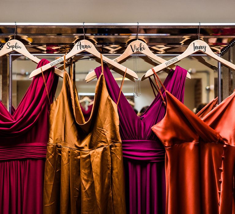 Red, purple, yellow and orange bridesmaids dresses in autumnal jewel colours for lesbian wedding at Foxtail Barns venue