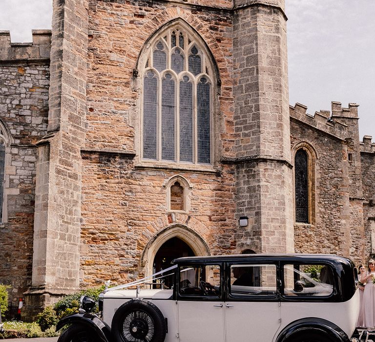 Black and white vintage wedding car transportation for traditional church wedding 