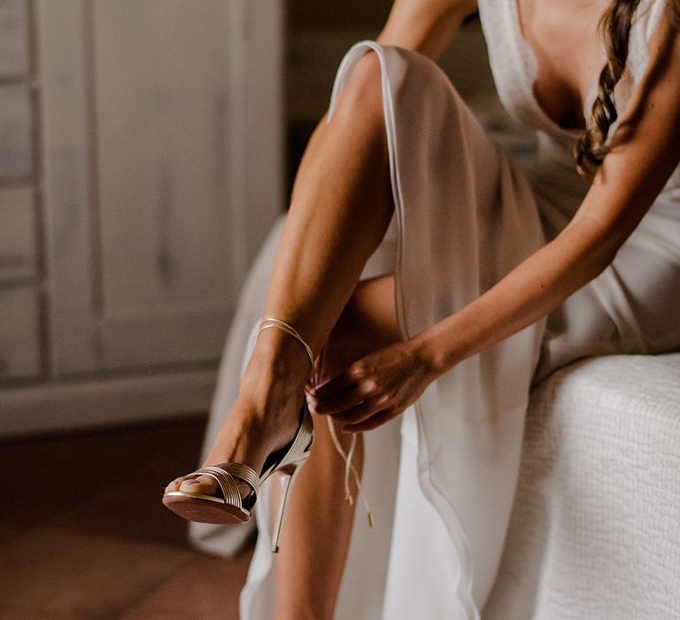 Bride wears gold heels on her wedding day complete with ankle strap and peep toe style 