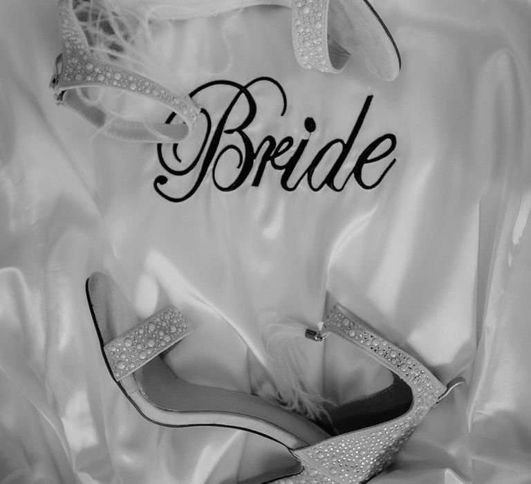 White satin bride embroidered robe with white heeled shoes embellished with gems and white feathers