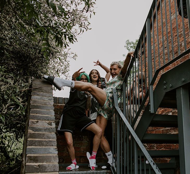 Groom poses with his bridesmaids outdoors on the morning of his wedding day