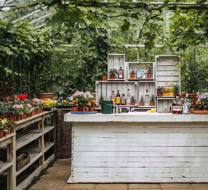 The West Green House reception venue with white bar surrounded by green foliage