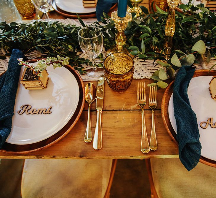 Rustic tablescape with macrame table runner, plant favours in personalised wooden box and pops of gold throughout