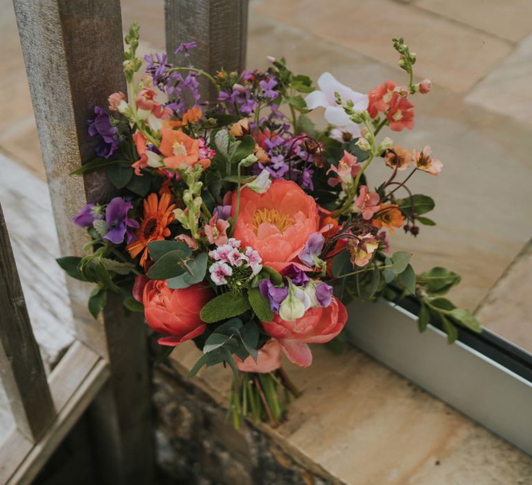 Colourful floral bouquet with orange peonies and green foliage 