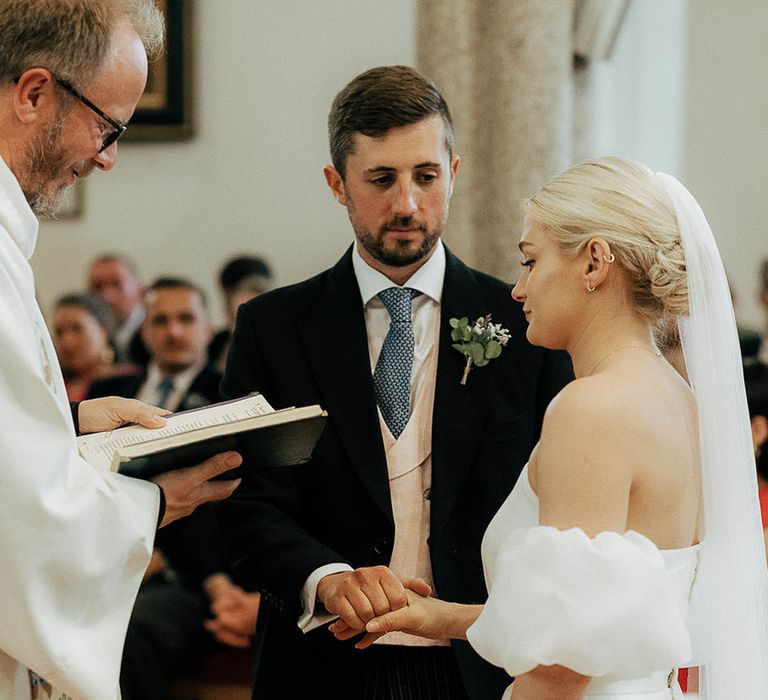 Bride & groom during wedding vows in church ceremony 