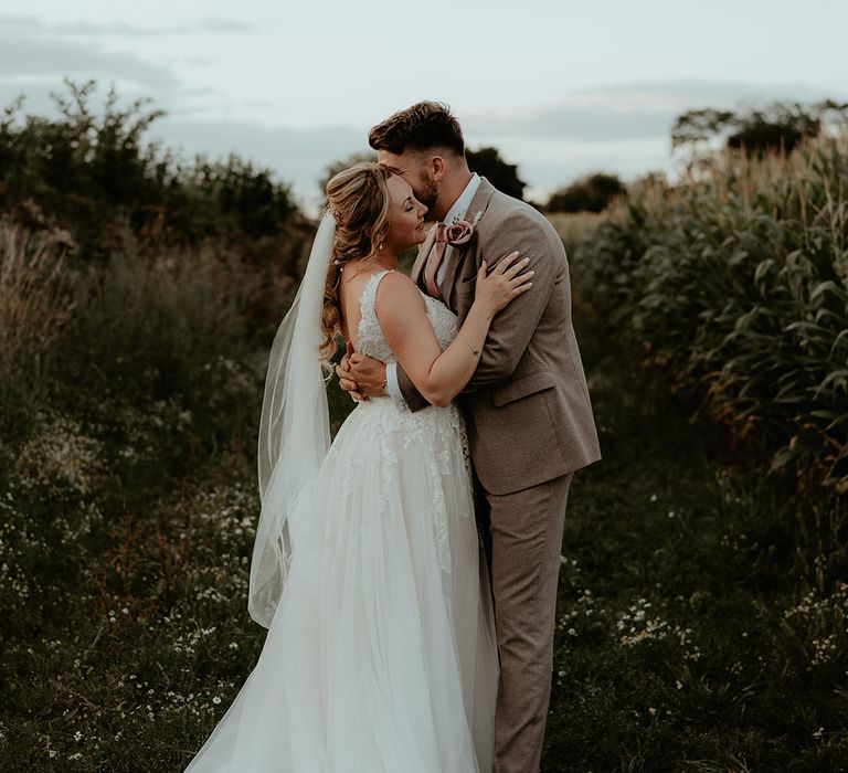 Bride & groom kiss outdoors at The Apple Orchard during couples portraits 