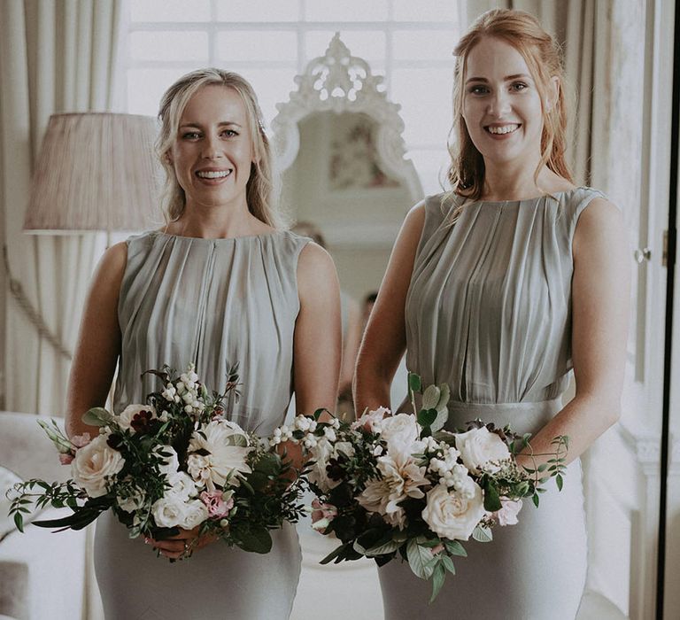 Bridesmaids wear high neck sage green bridesmaid dresses with classic styled bridal bouquets for Hedsor House wedding 