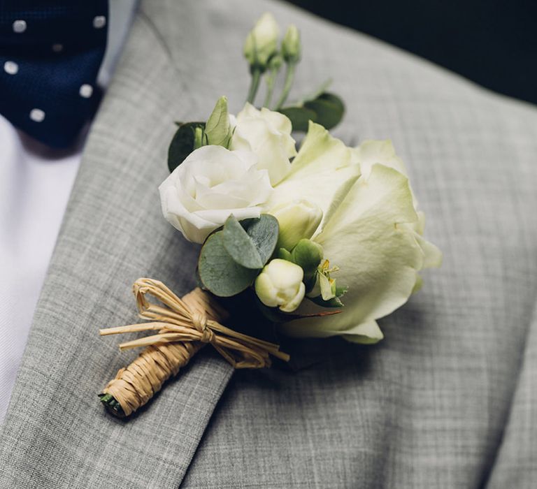 Groom in grey suit with navy polka dot pocket square with white flower buttonhole 