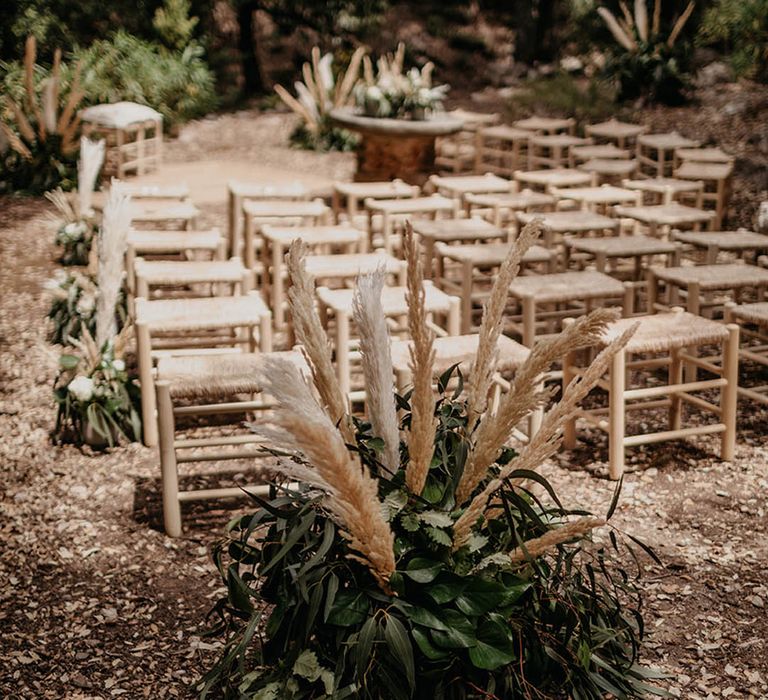 Wedding aisle decor with arrangement made of foliage and pampas grass 