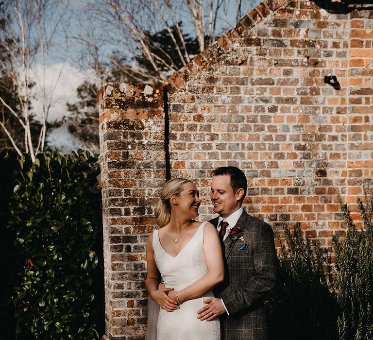 Bride in fitted Karen Willis Holmes wedding dress smiling with the groom during golden hour for spring wedding 