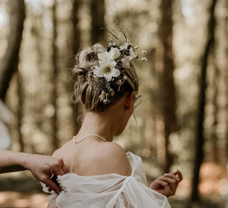 Bride in strapless Milla Nova wedding dress with floral embroidered detail with tulle detachable sleeves with white flower hair accessory 