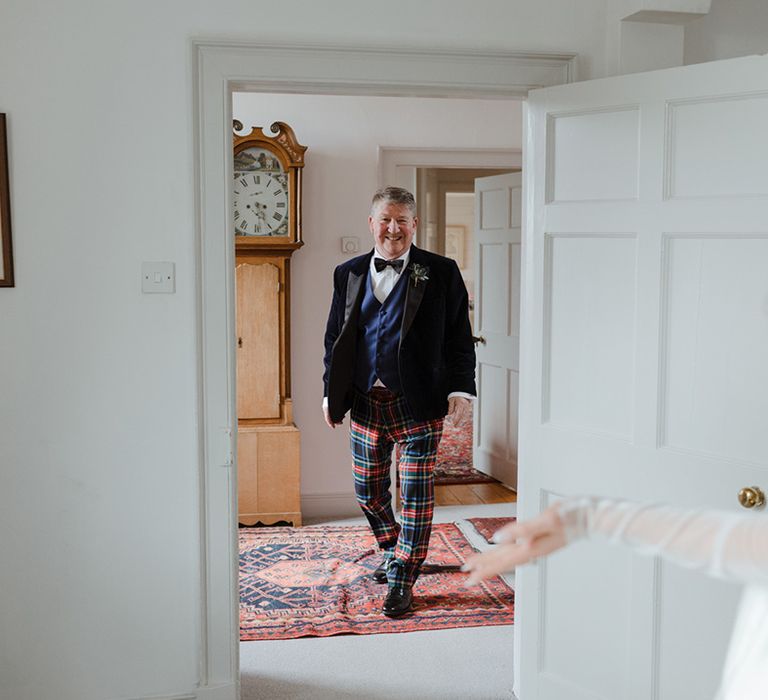 Father of the bride in tuxedo and tartan trousers gets to see the bride 