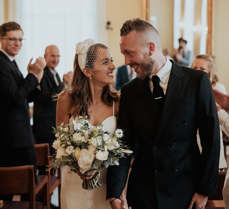 Chelsea registry office wedding with bride in separates and birdcage veil holding a white and green wedding bouquet 