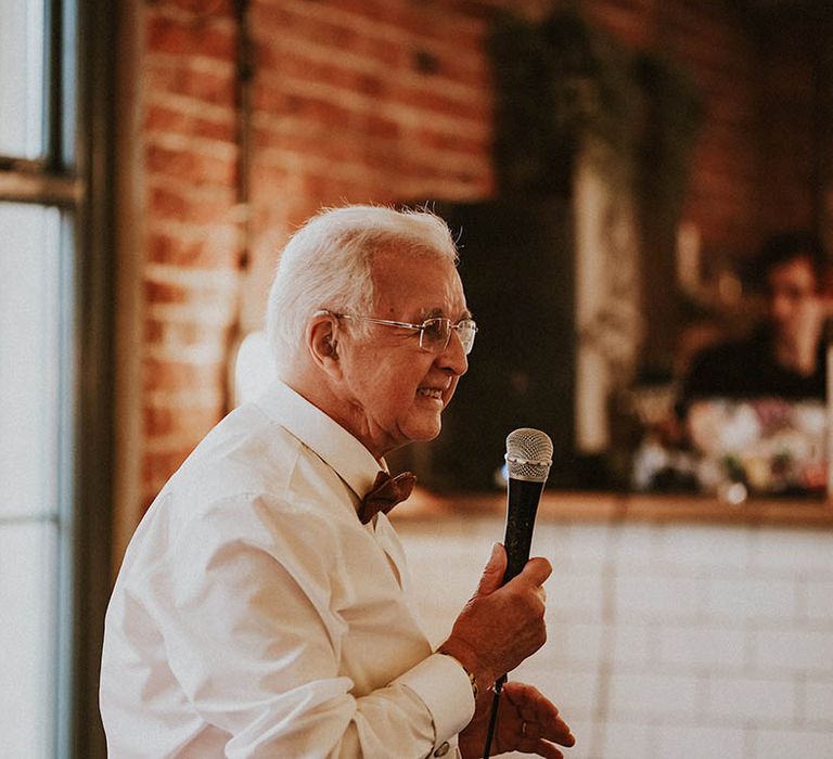 Father of the bride in white shirt performing wedding speech 