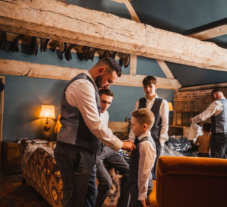 The groom, his son, and groomsmen get ready for the wedding together 