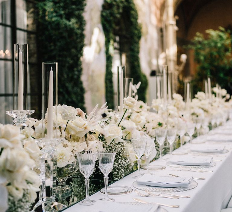 Romantic and elegant classic white wedding tablescape with white wedding flowers and candles 