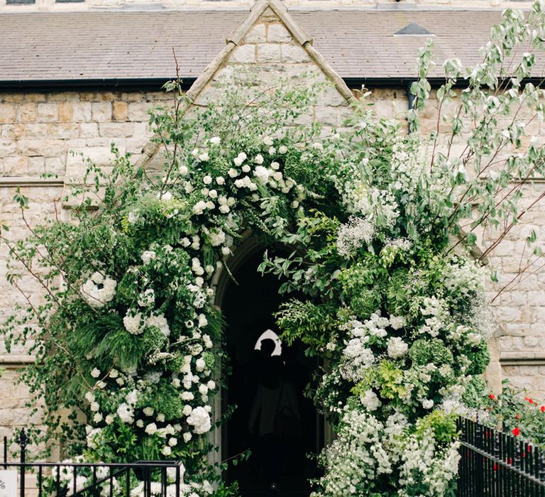 Extravagant luxury white flower wedding arch at the entrance to the church wedding 