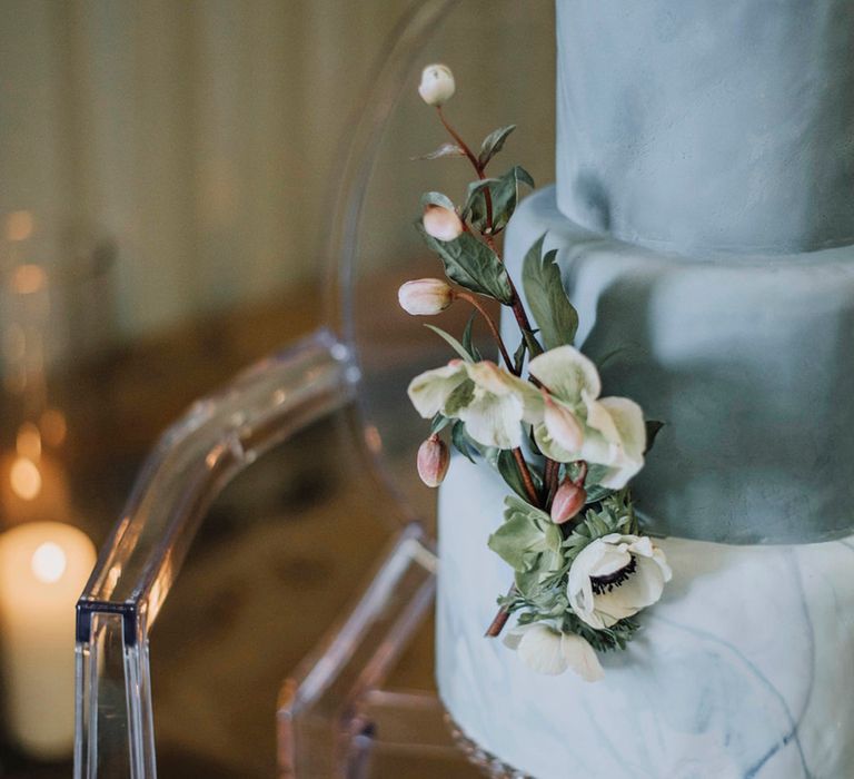 Powder blue tiered wedding cake with floral decorations 