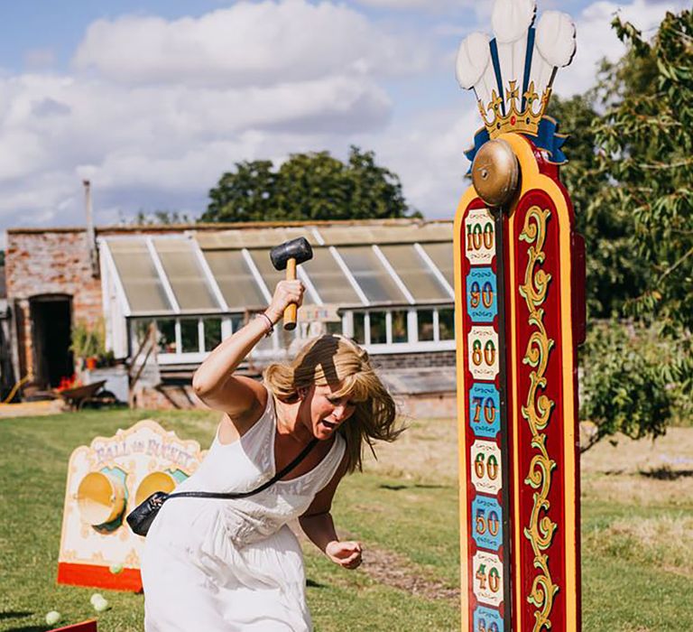 Wedding guest plays carnival game at festival themed wedding 