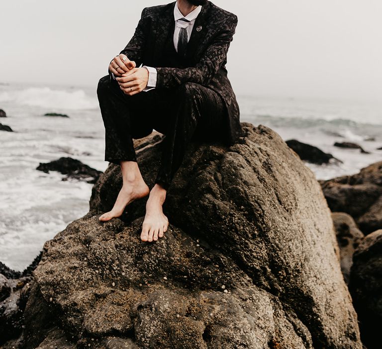 Stylish groom in black patterned suit 