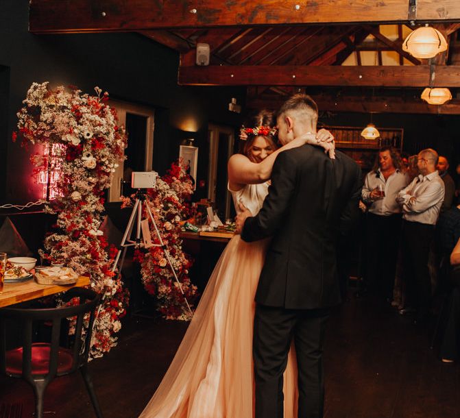 Brickyard Vineyard Wedding first couple dance with red wedding flowers