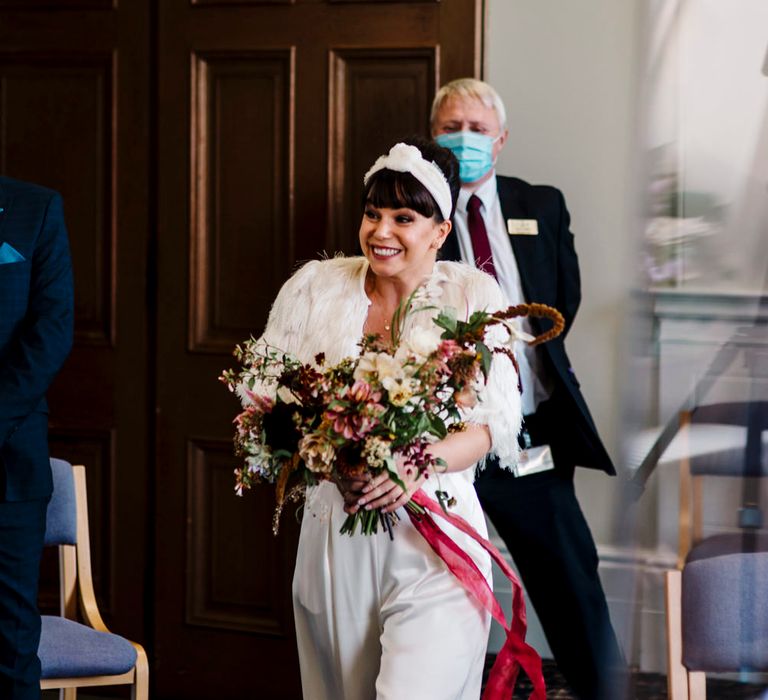 Wedding ceremony bridal entrance in trouser suit and headband 