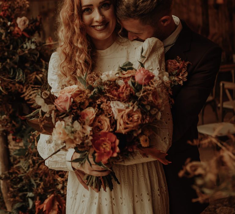 Groom nuzzling his brides neck 